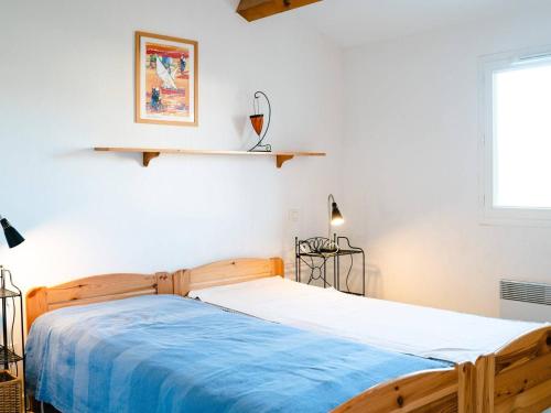- une chambre avec un lit en bois et une couverture bleue dans l'établissement Villa moderne avec jardin et terrasse, 2 chambres + mezzanine, proche plage - Narbonne-Plage - FR-1-409-102, à Narbonne-Plage