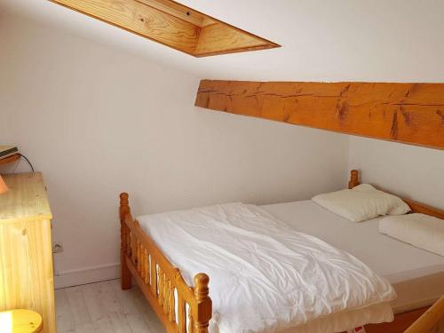 - une chambre avec un lit doté d'un cadre en bois dans l'établissement Pavillon cosy avec terrasse, 5 couchages, proche plage et nature, animaux bienvenus - FR-1-409-95, à Narbonne-Plage