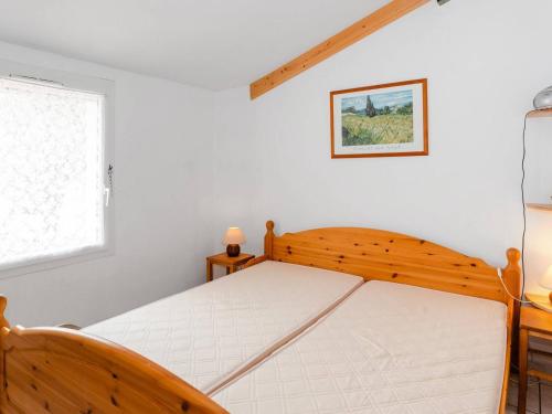 um quarto com uma cama com uma estrutura em madeira em Villa Narbonne-Narbonne Plage-Narbonne Plage, 3 pièces, 4 personnes - FR-1-409-112 em Narbonne Plage