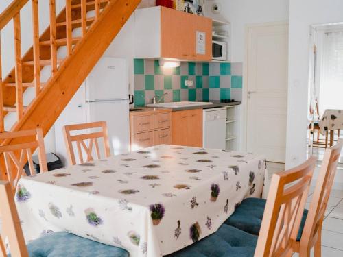 une cuisine avec une table et des chaises ainsi qu'un escalier dans l'établissement Pavillon 4 pièces avec garage, terrasse, et tout confort à Narbonne-Plage, 5 couchages - FR-1-409-115, à Narbonne-Plage