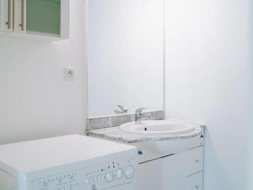 une salle de bain blanche avec un lavabo et un miroir dans l'établissement Pavillon 4 pièces avec garage, terrasse, et tout confort à Narbonne-Plage, 5 couchages - FR-1-409-115, à Narbonne-Plage