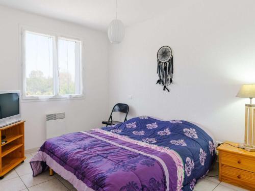 - une chambre avec un lit violet et une télévision dans l'établissement Villa spacieuse 4 pièces, 6 couchages, terrasses ensoleillées, animaux acceptés, parking, proche plage - FR-1-409-127, à Narbonne