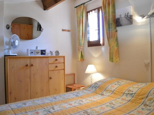 une chambre avec un lit, une commode et un miroir dans l'établissement Maison cosy avec mezzanine, à 800m de la plage, 6 couchages, terrasse et parking privé - FR-1-229D-29, à Fleury