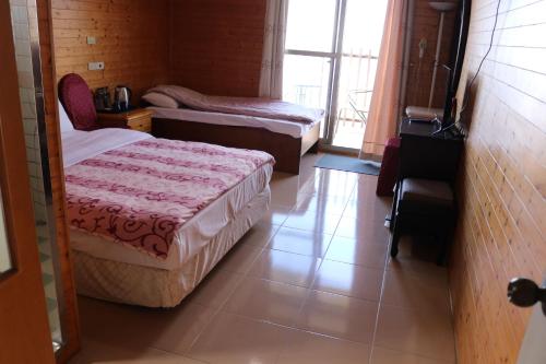 a small bedroom with two beds and a window at 星光山悦景觀民宿 in Heping