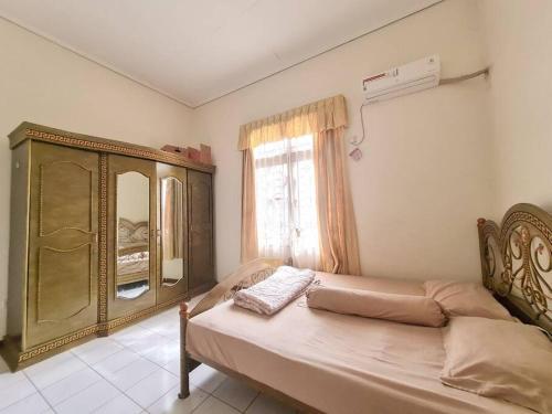 1 dormitorio con 1 cama, vestidor y ventana en Homestay Pesona Sintuk Bontang A8, en Bontang