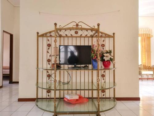 a tv sitting on a glass stand in a room at Homestay Pesona Sintuk Bontang A8 in Bontang
