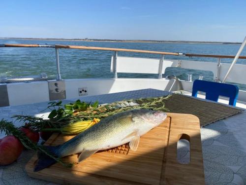 a fish on a cutting board on a table on a boat at Iate Glória Sem-fim Monsaraz in Monsaraz