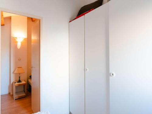 Cette chambre dispose d'armoires blanches et d'un miroir. dans l'établissement Pavillon climatisé 3 pièces avec mezzanine, terrasse, à 200m de la plage - 6 couchages - FR-1-409-153, à Narbonne-Plage