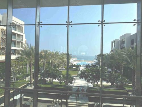 a view of a beach from a building window at Lyoan home in Ḩayl Āl ‘Umayr