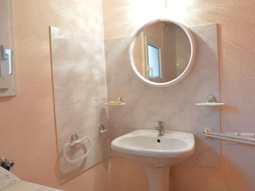 une salle de bain avec un lavabo et un miroir dans l'établissement Maison proche plage et commerces, 3 pièces, climatisée, 6 couchages, animaux acceptés - FR-1-229D-57, à Fleury