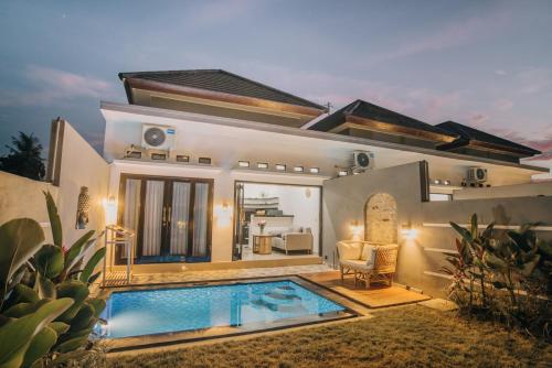 a villa with a swimming pool in front of a house at villa mediterania kerobokan buleleng in Babakan Sangsit