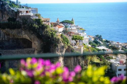 a village on a cliff next to the ocean at Hotel Pellegrino in Praiano