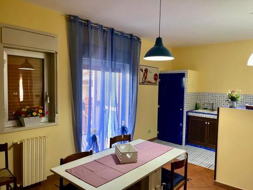cocina con mesa y cortina azul en Benvenuti a Casa Sicilian Apartment Palermo, en Termini Imerese
