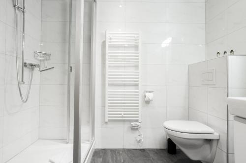 La salle de bains blanche est pourvue d'une douche et de toilettes. dans l'établissement Apartment Babice 2.0 - GRIWA RENT AG, à Grindelwald