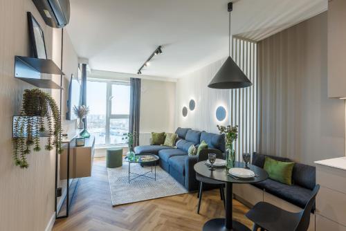 salon z niebieską kanapą i stołem w obiekcie Emihouse KrakoVska Apartments w mieście Rzeszów