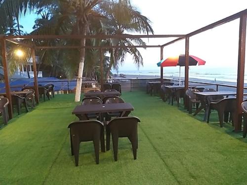 a row of tables and chairs with the ocean in the background at zoz Mg in Old Goa