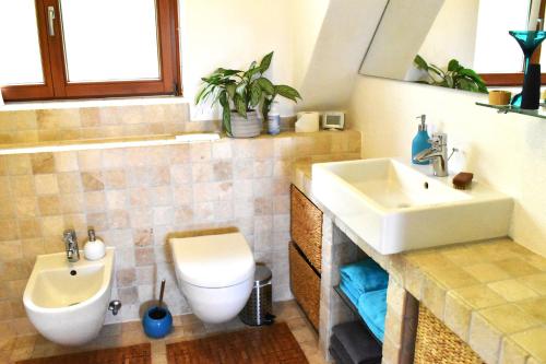 a bathroom with a white sink and a toilet at Mediterran-Skandinavisch - Outdoorwhirlpool ganzjährig in Burgthann