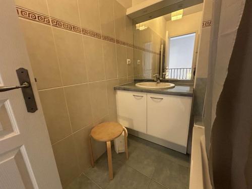 une petite salle de bain avec un lavabo et un tabouret dans l'établissement Charmant duplex climatisé 3 pièces avec jardinet et garage privé - 6 couchages, Aigues-Mortes - FR-1-250-177, à Aigues-Mortes