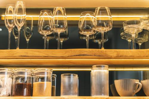 a shelf with many wine glasses on it at Royal View Apartments in Kirkby Lonsdale