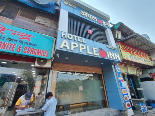 two men standing in front of a hotel appedia at Hotel Apple Inn - Santacruz in Mumbai