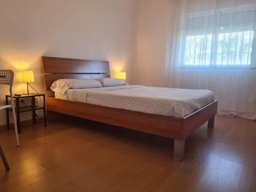 a bedroom with a large bed with a window at Harbour's way, spacious and cosy apartment, with AC in Olhão