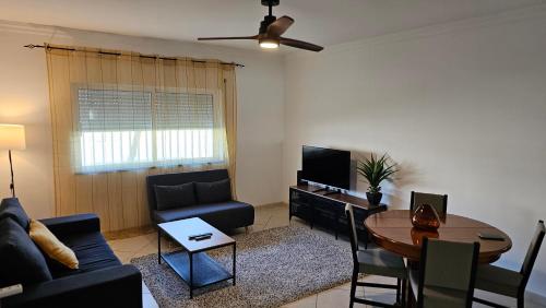a living room with a couch and a table at Harbour's way, spacious and cosy apartment, with AC in Olhão