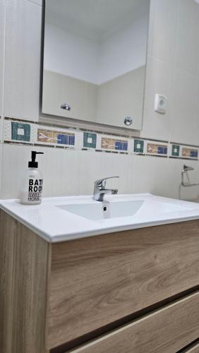 eine Badezimmertheke mit einem Waschbecken und einem Spiegel in der Unterkunft Harbours Way in Olhão