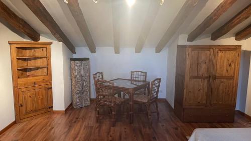 a dining room with a table and chairs and wooden floors at Las Tongueras in Pedraza-Segovia