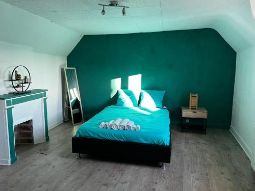 - une chambre avec un lit bleu et un mur vert dans l'établissement T2 proche du château de Blois, à Blois