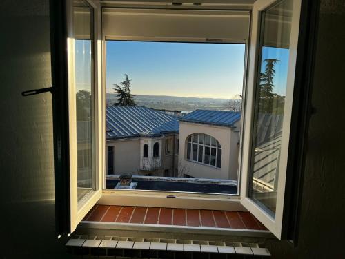 une fenêtre avec vue sur une maison dans l'établissement T2 proche du château de Blois, à Blois