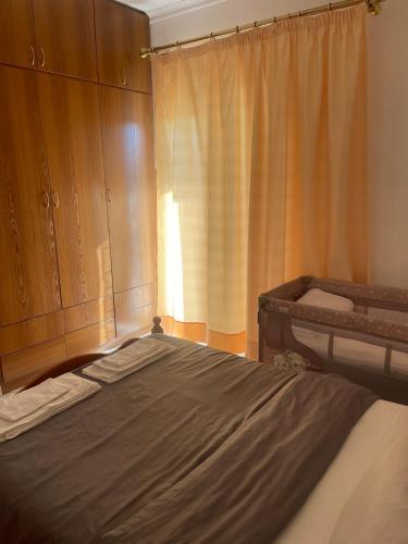a bedroom with a bed and wooden cabinets at Trikala Comfort Stay in Tríkala