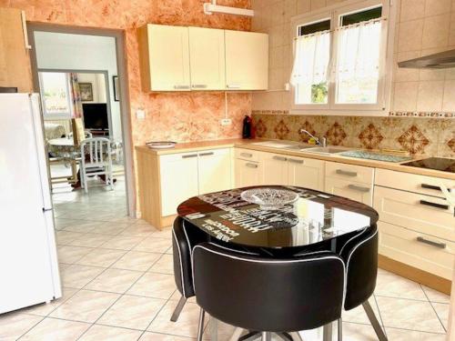 une cuisine avec une table et des chaises dans l'établissement Spacieux F2 ensoleillé de 62m², climatisé, balcon, parking, proche cures et centre, animaux acceptés - FR-1-703-121, à Amélie-les-Bains-Palalda