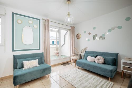 a living room with two blue couches and a window at Hexa Dream in Montévrain