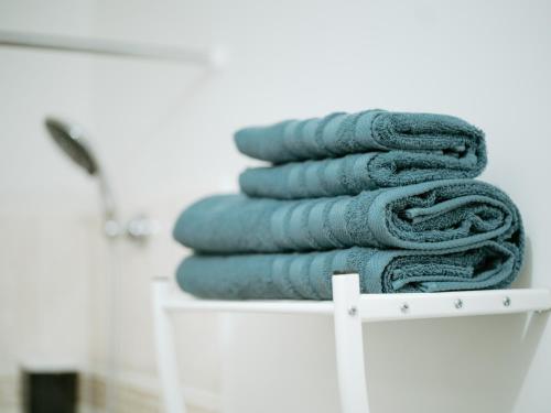 a stack of towels sitting on a white shelf at Hexa Dream in Montévrain