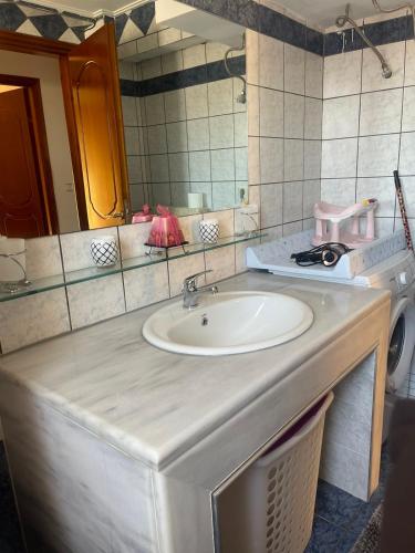 a bathroom counter with a sink and a mirror at Bright apartment, spacious near the center in Tríkala