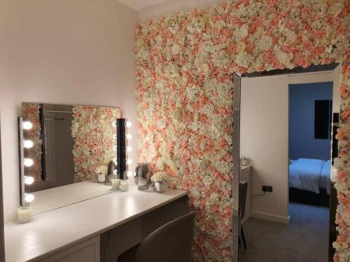 a bathroom with a vanity with a flower patterned wall at Stunning 1 Bed Apt Minutes From Bham City Centre! in Birmingham