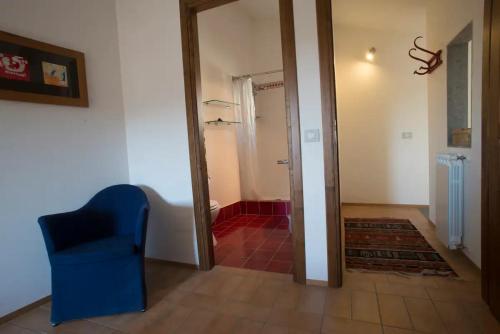 a room with a blue chair and a bathroom at Le Terrazze della Tuscia in Latera