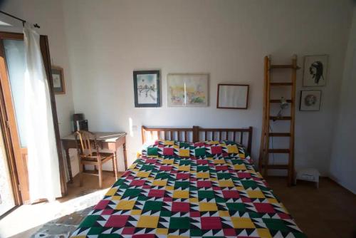 a bedroom with a bed with a colorful quilt at Le Terrazze della Tuscia in Latera