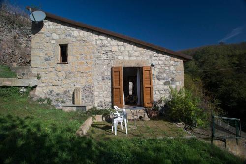 a stone building with a table and chairs in front of it at Le Terrazze della Tuscia in Latera