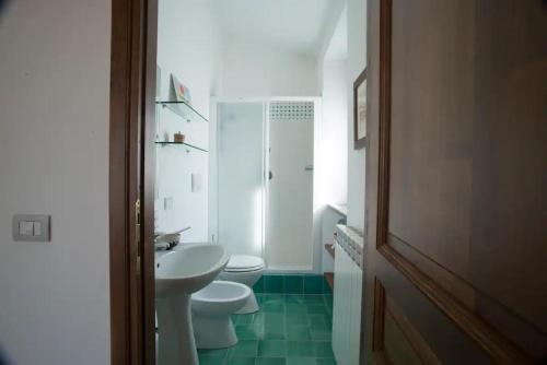 a white bathroom with a toilet and a sink at Le Terrazze della Tuscia in Latera