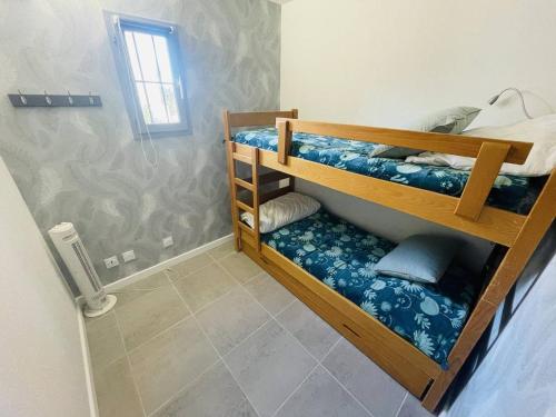 une chambre avec deux lits superposés dans une pièce dans l'établissement Appartement rénové près de la plage Richelieu avec piscine, garage et vélos fournis - FR-1-723-113, au Cap d'Agde