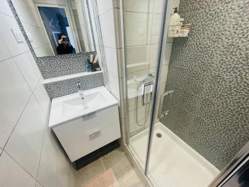 une salle de bain avec une douche, un lavabo et un miroir dans l'établissement Appartement rénové près de la plage Richelieu avec piscine, garage et vélos fournis - FR-1-723-113, au Cap d'Agde