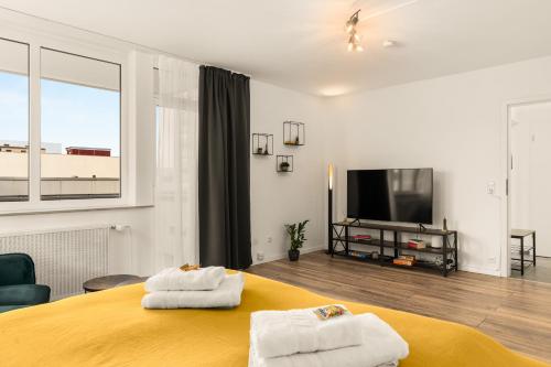 a bedroom with a yellow bed and a flat screen tv at FREE LIVING - City Design Apartments, Zentrum, Outlet, Balkon, Küche in Wolfsburg