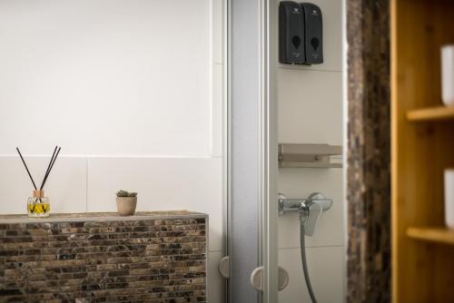 a shower in a bathroom with a brick wall at FREE LIVING - City Design Apartments, Zentrum, Outlet, Balkon, Küche in Wolfsburg
