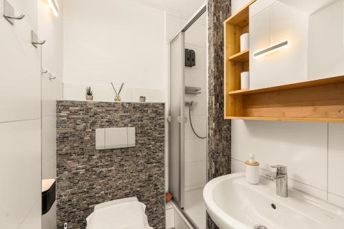 a bathroom with a toilet and a sink at FREE LIVING - City Design Apartments, Zentrum, Outlet, Balkon, Küche in Wolfsburg