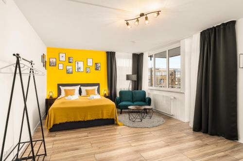 a bedroom with a bed and a yellow wall at FREE LIVING - City Design Apartments, Zentrum, Outlet, Balkon, Küche in Wolfsburg