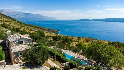 an image of a house with a view of the water at Dalmatian stone villa with heated pool in Lokva Rogoznica