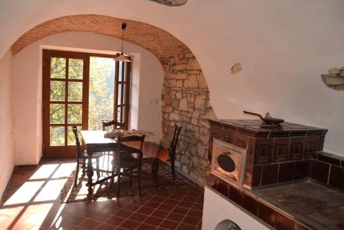 a kitchen with a table and a stone oven in a room at Vejminek Hynčina 