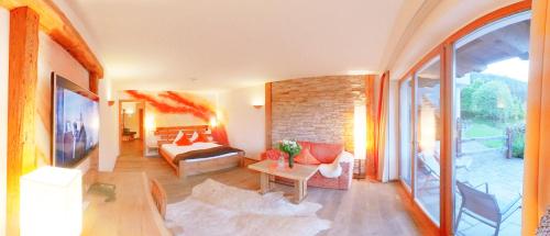 a living room with a couch and a table at Feuriger Tatzlwurm Berghotel & Spa, BW Signature Collection in Oberaudorf
