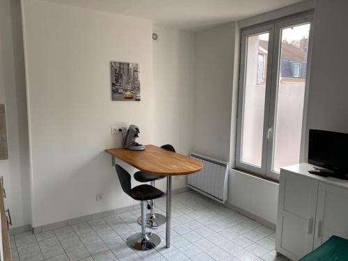ノジャン・シュル・セーヌにあるStudio hypercentre Abbatial 431の木製テーブルと椅子が備わる客室です。